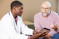 Young-doctor-showing-older-male-patient-ipad-article.jpg
